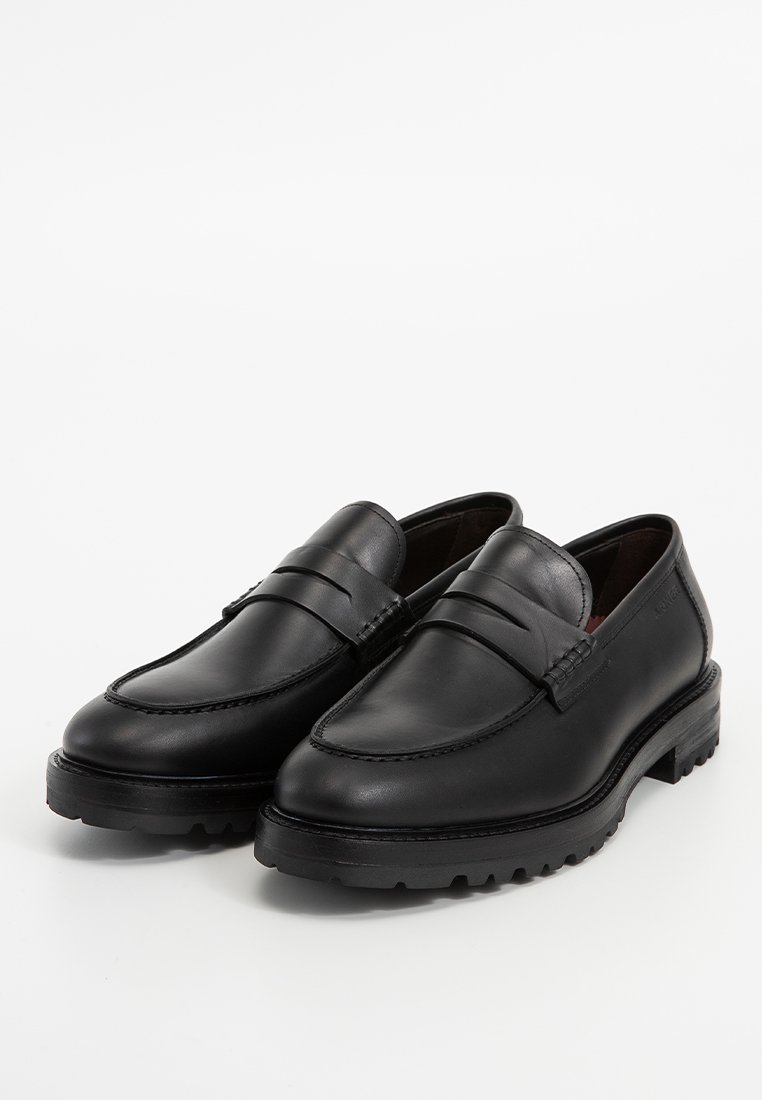 Zwarte leren loafers met een gladde textuur, ronde neus, dubbele horizontale banden en een robuuste zool. Beschikt over contrasterende stikseldetails.