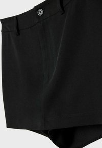 Black shorts made from a smooth fabric. Features a button closure, flat waistband, and straight-cut design, with minimal side stitching.