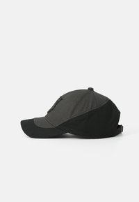 Svart og grå baseballcaps laget av stoff, med buet skjerm, justerbar stropp og en logo-lapp på siden.