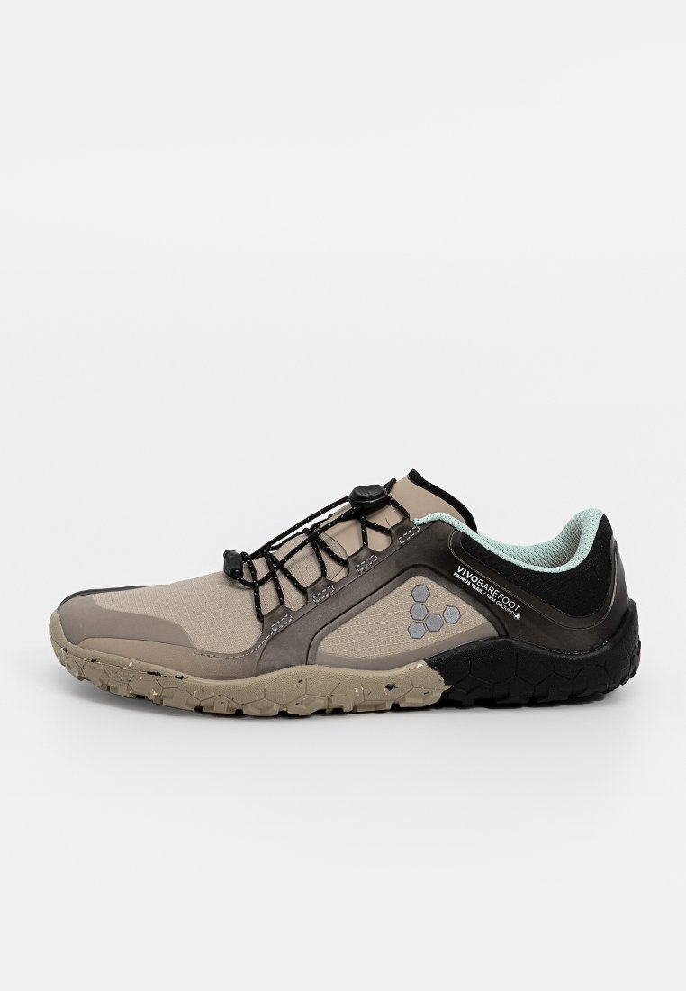 Zapatilla en tonos marrón y negro con una superficie texturizada, un diseño ligero, cordones elásticos y una suela negra con un agarre estampado.