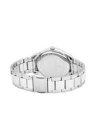 Montre en acier inoxydable argenté avec un bracelet à maillons et un boîtier rond. L'arrière présente un logo de marque gravé et une surface texturée. Pas de cadran visible.