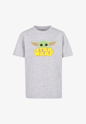 Šedé tričko s krátkym rukávom s rozprávkovou postavou so zelenou pokožkou a veľkými čiernymi očami a textom "STAR WARS" v žltej farbe pod ňou.