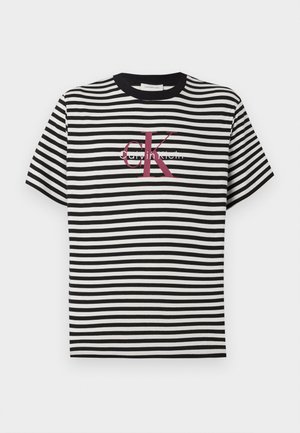 Svartvit randig t-shirt med rund hals och korta ärmar. Framsidan visar "Calvin Klein" med ett framträdande röd "K" som accent.
