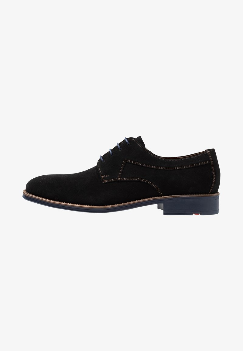 Chaussure habillée pour homme en daim noir avec des lacets bleus, des coutures marron et un talon bas empilé sur fond blanc.