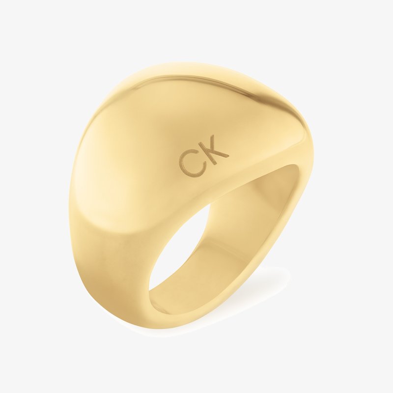 Gold-toned metal ring with a smooth, curved design. Engraved "CK" logo on the surface, featuring a glossy finish and rounded shape.