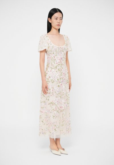 Kvetinové vyšívané šaty z priehľadnej látky, s krátkymi nafúknutými rukávmi, v farbách ružovej, zelenej a bielej, s trblietavými detailmi po celom oblečení.