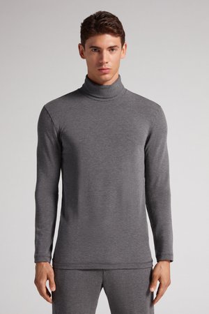 Grå turtleneck langærmet bluse lavet af et blødt, strækbart stof; har et tætsiddende design med en ribbet krave og sømløse ærmer.