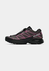 Black athletic shoe with pink accents, mesh upper, and a rounded toe. Features a quick-lacing system and a textured rubber outsole.