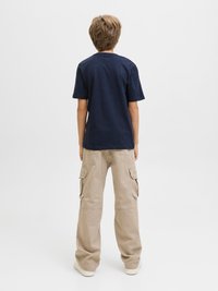 Temno modra bombažna majica s kratkimi rokavi, kombinirana s svetlo bež cargo hlačami s stranskimi žepi in sproščenim krojem.