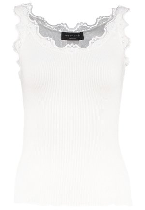 Valge sooniktop lace äärisega kaelusel ja varrukatel. Omab pehmet tekstuuri ja lähedast lõiget. Brändi silt on nähtav seestpoolt.
