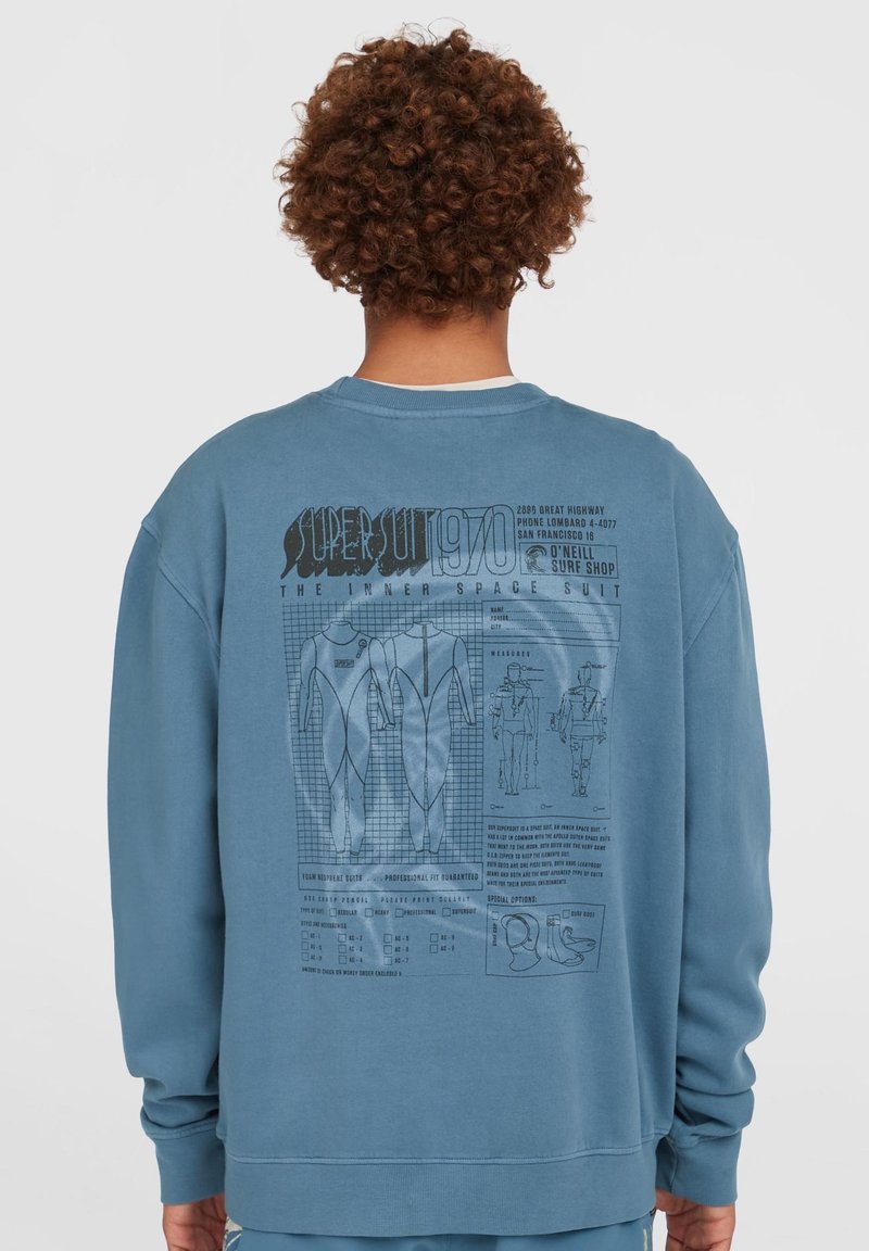 Blå sweatshirt med grafik på ryggen af en våddragt, der inkluderer designskitser, tekst og afkrydsningsfelter. Blødt stof og afslappet pasform.