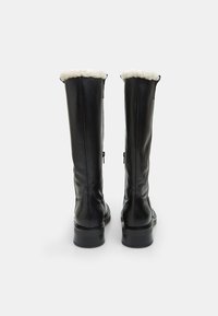 Bărăști negre din piele, până la genunchi, cu un guler din blană artificială de culoare crem, textură netedă și un accent stylish cu fermoar pe lateral. Talpă din cauciuc pentru durabilitate.