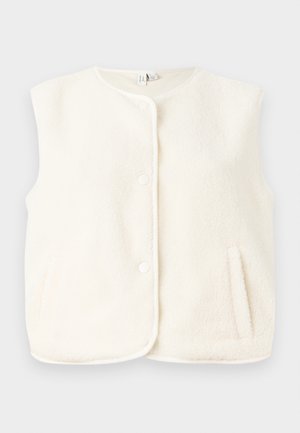 Fleece vest i kremfarge, uten ermer, med frontknapper og sidelommer. Myk tekstur med en glatt innerfore.