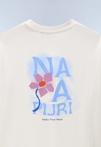 Λευκό βαμβακερό μπλουζάκι με εκρού απόχρωση που διαθέτει γαλάζιο γραφικό σχέδιο με μεγάλα γράμματα και εικονογράφηση με ροζ λουλούδι. Το κείμενο γράφει "Κάνε το Στίγμα σου".