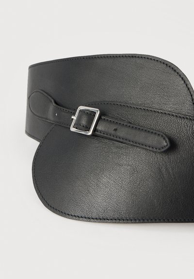 Μαύρη δερμάτινη ζώνη με λεία υφή, φαρδιά σχεδίαση και τετράγωνη ασημί αγκράφα για ρύθμιση. Οι άκρες είναι ραμμένες για ανθεκτικότητα.