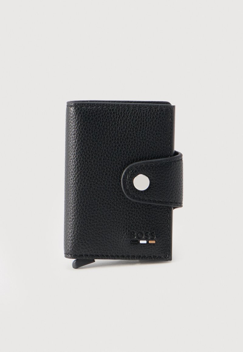 Μαύρο πορτοφόλι από δερματίνη με υφή, με κούμπωμα κουμπί και μικρό ανάγλυφο λογότυπο της μάρκας στην κάτω δεξιά γωνία.