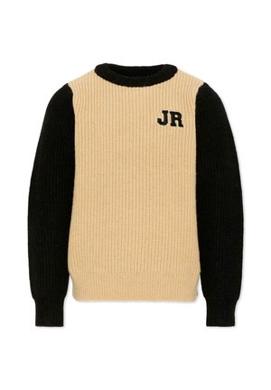 Pull en maille beige avec manches longues noires et col, avec des lettres noires "JR" brodées sur la partie supérieure gauche de la poitrine.