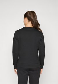 Zwarte crewneck sweatshirt met lange mouwen, gemaakt van zacht materiaal. Strak bij de taille, met een eenvoudig ontwerp en minimale stiksels.