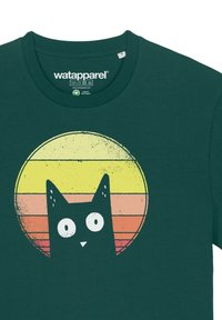 Dunkelgrünes T-Shirt mit einem bedruckten Grafikmotiv eines schwarzen Katers vor einem stilisierten, kreisförmigen Sonnenuntergang mit gelben, orangen und pinken Streifen.