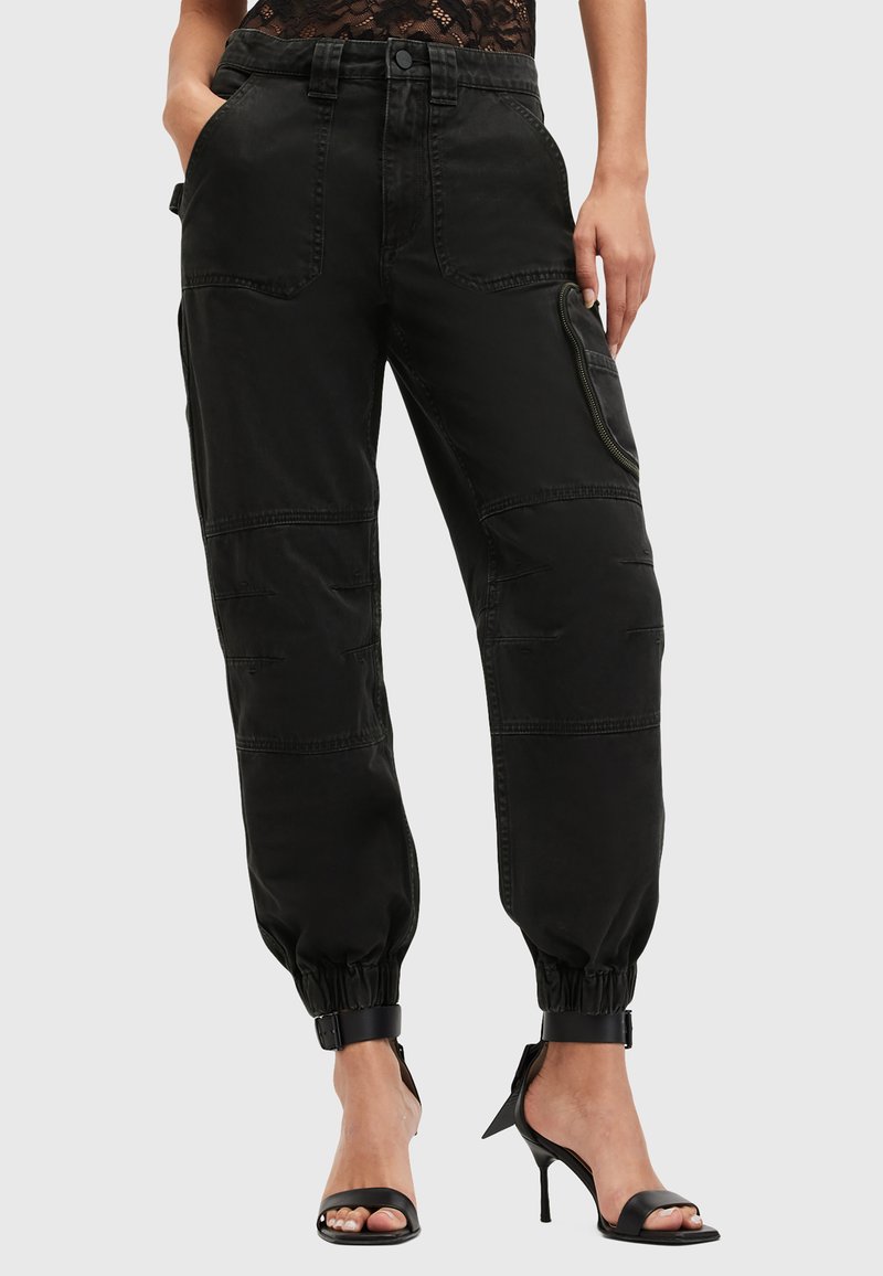 Zwarte cargobroek met elastische boorden, meerdere zakken, een relaxed fit en een gestructureerde stof. Bevat een zipzak aan de zijkant.
