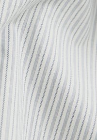 Tessuto di cotone con strisce bianche e azzurro chiaro, caratterizzato da una texture fine e un motivo ondulato. Le strisce sono spaziate in modo uniforme.