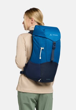 Sac à dos de randonnée bleu et marine avec une forme structurée, des sangles ajustables, un rabat supérieur et une poche avant. Il dispose d'une fermeture à cordon.