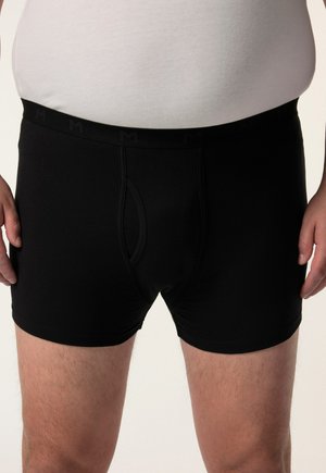 Boxers noirs en tissu doux avec une poche profilée, arborant une taille élastique avec un logo discret et des bords lisses.