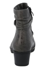 Botín de cuero gris hasta el tobillo con punta redondeada, tacón apilado y diseño plisado. Cuenta con un zipper lateral y un detalle de correa envuelta.