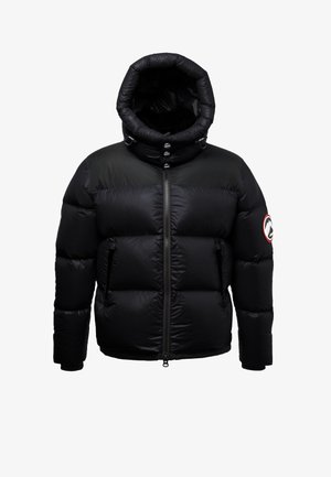Zwarte donzen jas met een hoge, opstaande kraag met ritssluiting en een vastgebouwde capuchon. Voorzien van een logopatch op de linkermouw en knoopdetails aan de voorkant.