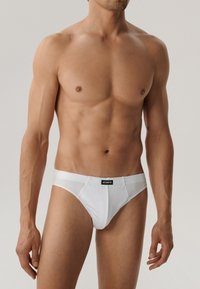 Białe bawełniane slipy z czarnym logo "ATLANTIC". Design cechuje dopasowany krój i gładka faktura, podkreślając minimalistyczny styl.