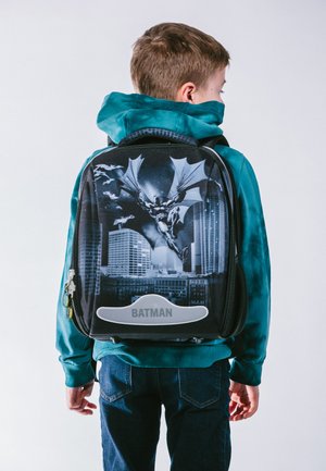 Zaino a tema Batman di colore nero con design della skyline della città e una grande grafica di Batman. Texture liscia, chiusure a zip e accentuazioni grigie.