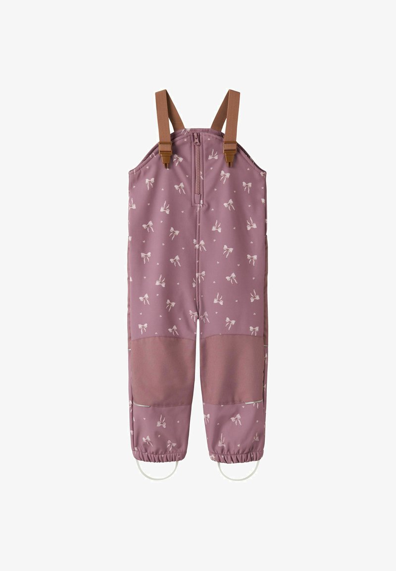 Salopette imperméable rose pour enfants avec motifs de nœuds blancs, bretelles réglables marron, genouillères et boucles élastiques pour les pieds.