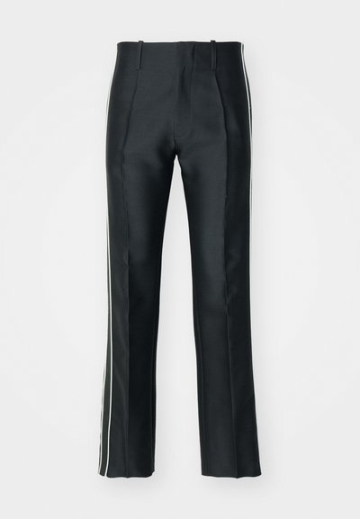Pantaloni neri in satin con una vestibilità su misura, caratterizzati da strisce laterali bianche. Progettati con gamba svasata e pieghe frontali per un tocco di dettaglio in più.