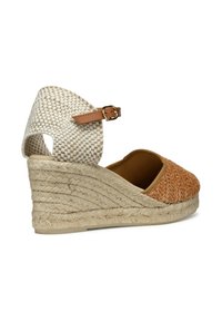 Sandalia de cuña con una punta de tejido texturizado naranja trenzado, suela de yute trenzado beige y parte trasera blanca con un estampado y correa para el tobillo marrón.