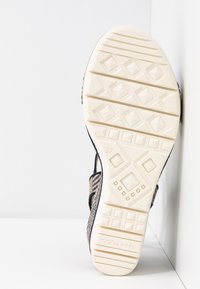 Semelle de sandale pour femme avec empeigne beige à motifs, semelle extérieure texturée, taille 37, et logo "Tamaris" sur la semelle blanche.