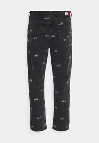 Vaqueros negros de denim con patrones repetidos de logotipo blanco. Presentan cinco bolsillos, un diseño de pierna recta y una etiqueta multicolor en la cinturilla.