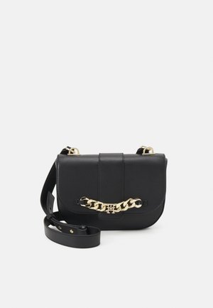 Borsa a spalla in pelle nera con un accento in catena dorata, forma quadrata, chiusura a pattina e tracolla regolabile. Texture liscia e design minimale.