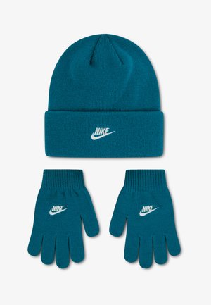 Tyrkysová pletená čiapka a pár rukavíc s bielym logom Nike na každom, zobrazené na obyčajnom svetlom pozadí.