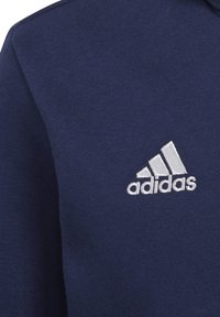 Felpa di cotone blu navy con logo Adidas ricamato bianco. Il tessuto ha una texture liscia e presenta un collo a giro.