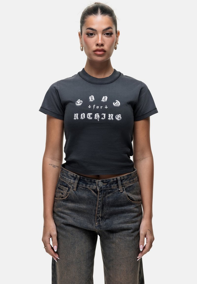 T-shirt noir court avec un texte graphique blanc indiquant « GOOD for NOTHING ». Le tissu semble doux, avec des manches courtes et une coupe classique.