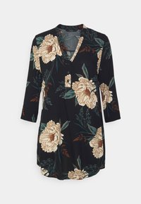 Svart tunika klänning med trekvartsärmar, prydd med stora beige blommor och gröna blad. Knappdetalj vid halslinningen förstärker Designen.