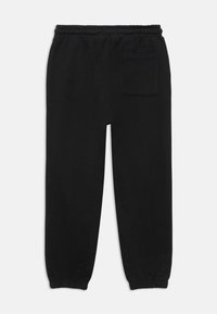 Black sweatpants with an elastic waistband, tapered cuffs, and a single back pocket. Smooth texture and simple, minimal design.