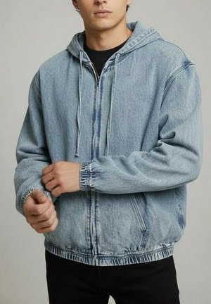 Veste en denim bleu clair à capuche avec fermeture éclair devant, poignets élastiques et coupe décontractée. Tissu texturé avec cordons de serrage à la capuche.