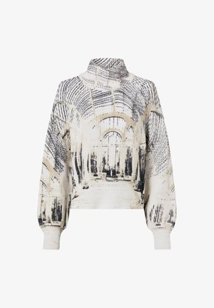 Pull col roulé avec texture côtelée, présentant des motifs abstraits d'arcs architecturaux noirs et beiges sur un fond blanc.