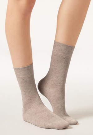 Hellbraune Baumwollsocken mit gerippten Bündchen und dezent gefleckter Textur, ausgestattet mit einer knöchellangen Länge und glattem Finish.