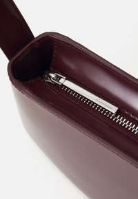 Calvin Klein REFINED SCULPT BAG SHINY - Geantă de mână - oxblood