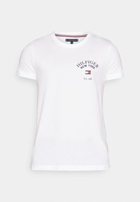 Camiseta de algodón blanca con cuello redondo, mangas cortas y un logotipo impreso con texto en color navy. Incluye un detalle del año de establecimiento.