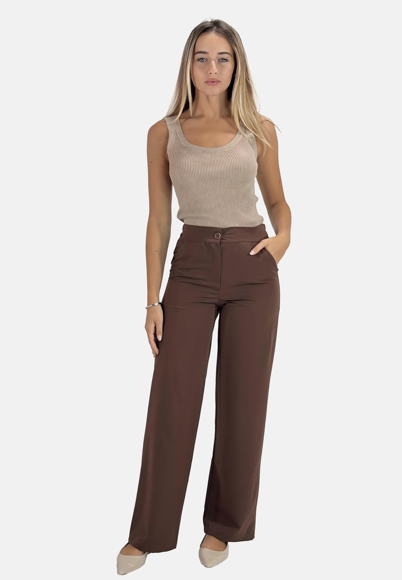 Beige geribbelde tanktop gecombineerd met high-waisted, brede bruine broek met een voorzijde knoop en twee zijzakken. Glad materiaal.