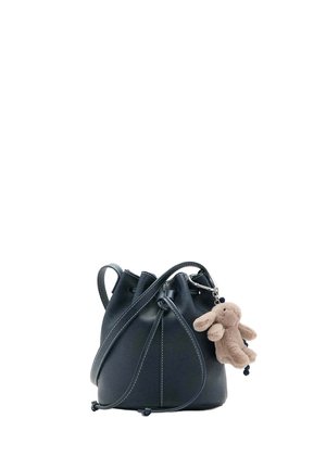Sac bourse en cuir noir avec cordon de serrage, bandoulière traversante et un petit porte-clés lapin en peluche beige attaché.
