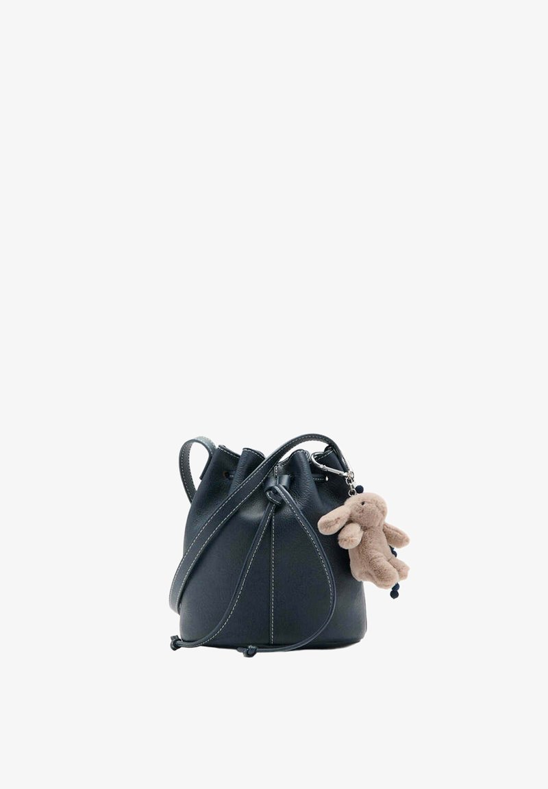 Sac bourse en cuir noir avec cordon de serrage, bandoulière traversante et un petit porte-clés lapin en peluche beige attaché.